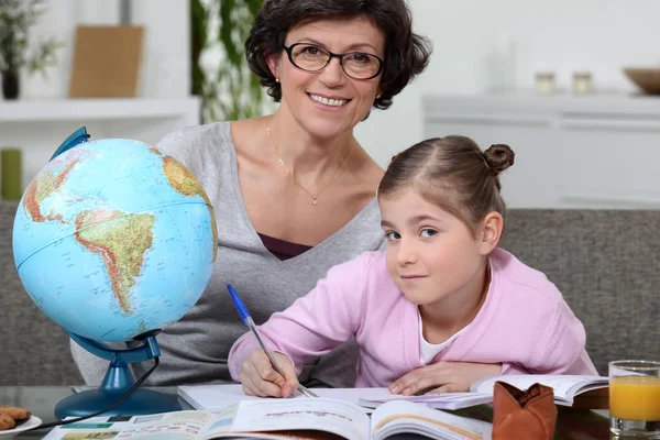 Kleines Mädchen macht Hausaufgaben mit ihrer Mutter — Stockfoto