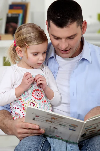 Отец читает сказку своей дочери — стоковое фото