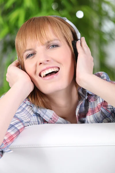 Gelukkige vrouw luisteren naar muziek op hoofdtelefoon — Stockfoto