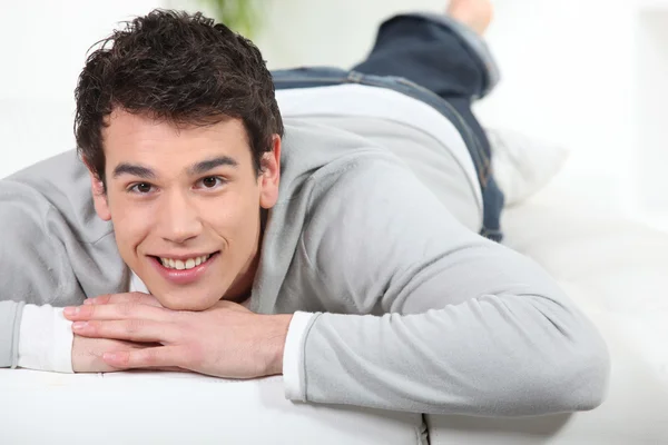 Jonge man liggen op een sofa — Stockfoto