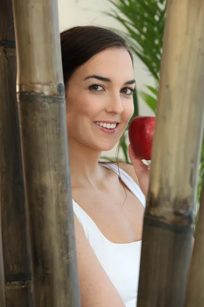 Frau isst einen roten Apfel in einem Wellnessbereich — Stockfoto