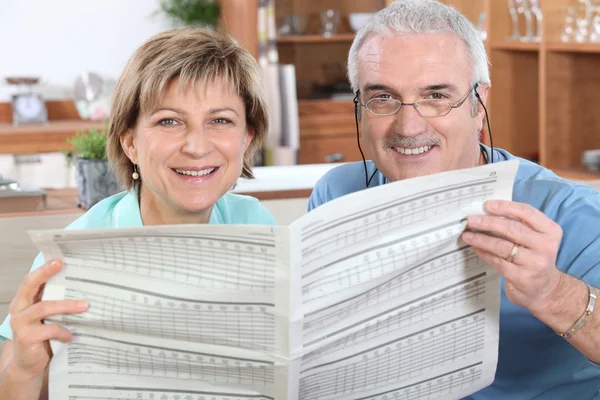 成熟夫妇在一起阅读一份报纸 — 图库照片