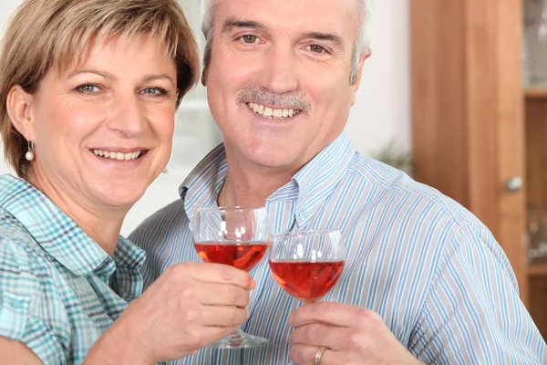 Μεσήλικο ζευγάρι πόσιμο κρασί στην κουζίνα — Φωτογραφία Αρχείου