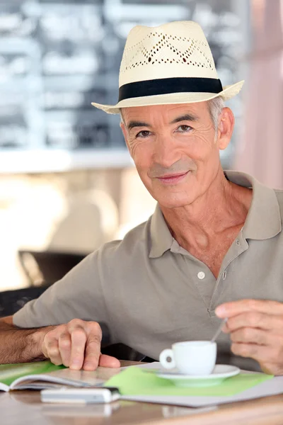 Elderly man drinking coffee on terrace — Stock Photo, Image