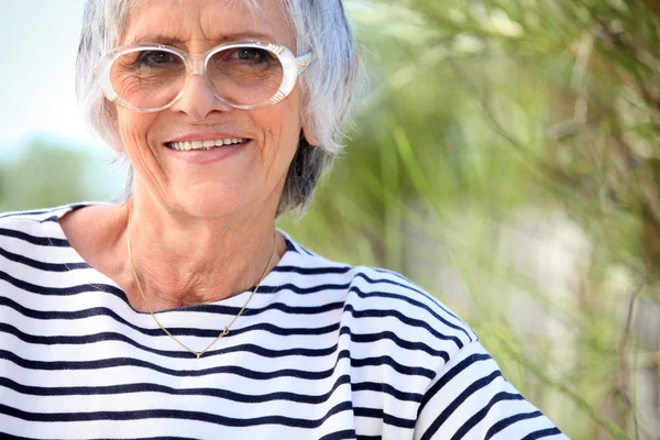 Oudere dame aan het strand — Stockfoto