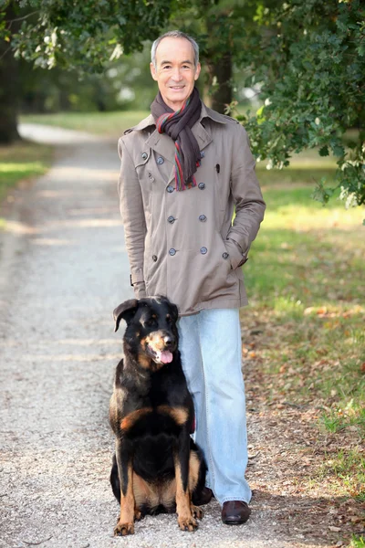 Senior lopen zijn hond — Stockfoto