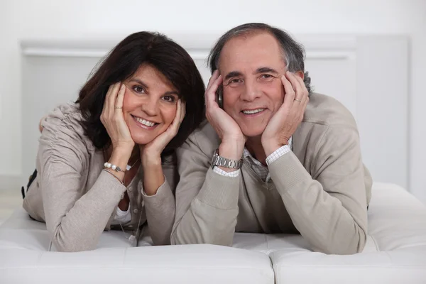 Mature couple lying on the couch — Stock Photo, Image