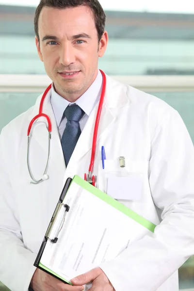 Männlicher Krankenhausarzt mit Klemmbrett — Stockfoto