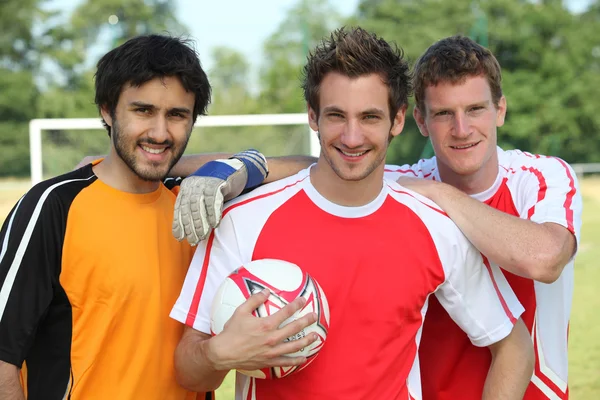 Drie voetballers voor doel — Stockfoto