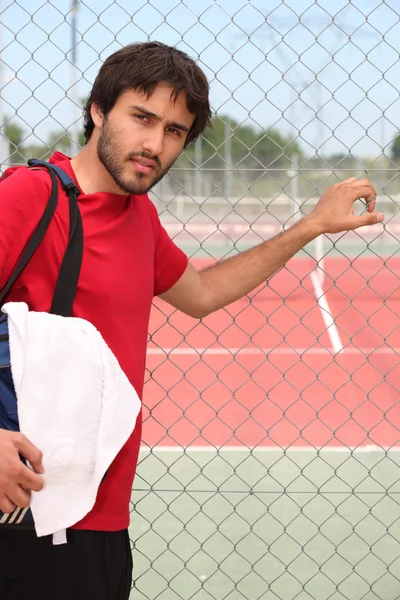 Jonge man buiten een tennisbaan — Stockfoto