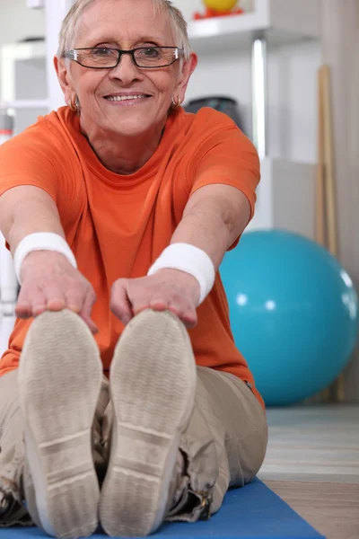 Yaşlı kadın egzersiz yaparak — Stok fotoğraf
