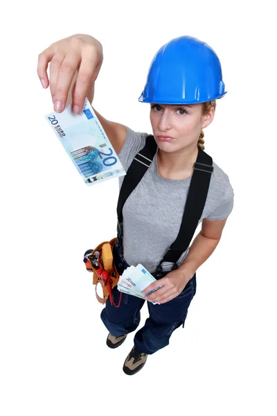Female electrician holding bank-notes — Stock Photo, Image