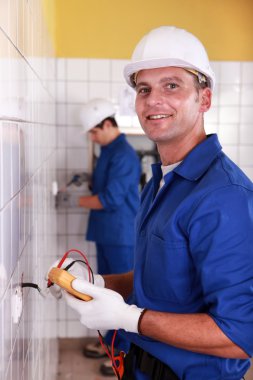 Worker performing an electrical test clipart