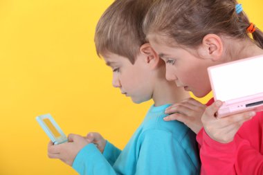 Children playing handheld video games clipart