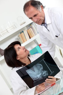 Doctor and assistant watching an x-ray clipart