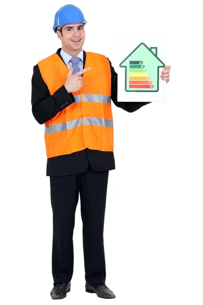 Man with helmet pointing at energy rating — Stock Photo, Image