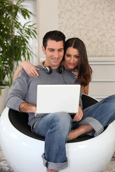 Látszó-on egy laptop, a hétköznapi fiatal pár — Stock Fotó