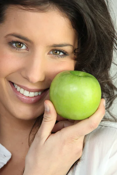 Młoda kobieta trzyma zielone jabłko — Zdjęcie stockowe