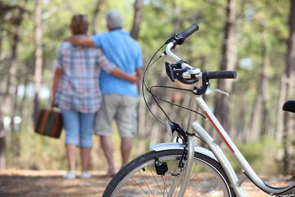 森の中を自転車でピクニックを取るカップル — ストック写真