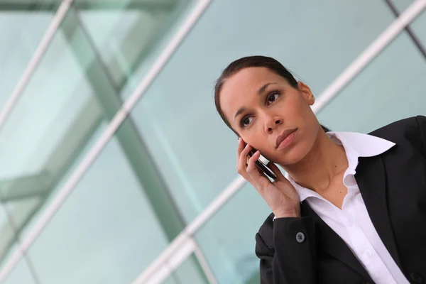 Donna d'affari che usa un cellulare fuori da un ufficio — Foto Stock