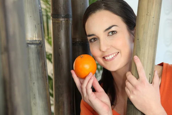 Женщина держит апельсин — стоковое фото