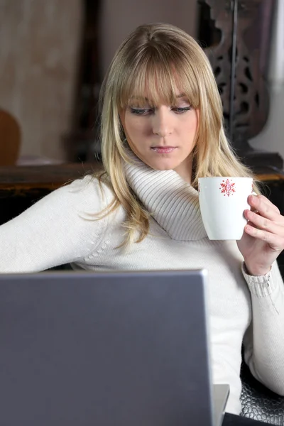 Woman in turtle-neck sweater holding mug of coffee — Stock Photo, Image