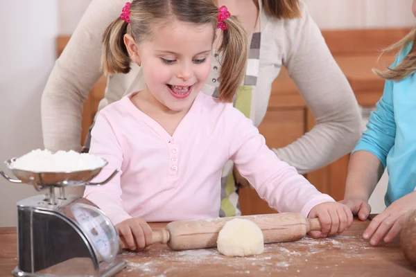 Маленькая девочка разворачивает тесто — стоковое фото