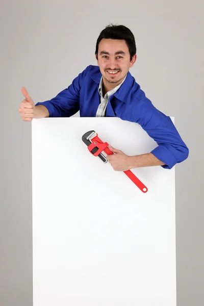 Mann mit Affenschlüssel und leerem Plakat — Stockfoto