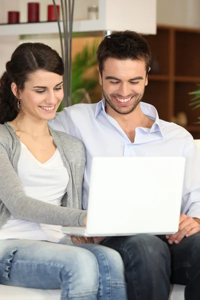 Casal usando um laptop em casa — Fotografia de Stock