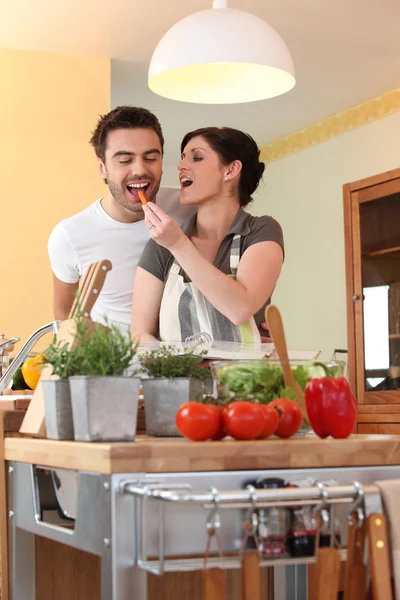 Uma mulher alimentando o marido com uma cenoura — Fotografia de Stock