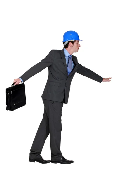 Beschwingter Vorarbeiter im Anzug mit Aktentasche vor weißem Hintergrund — Stockfoto