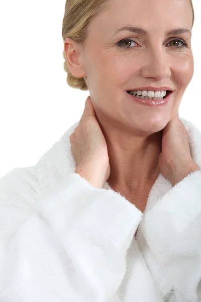 Γυναίκα στο μπάνιο ρόμπα, χαμογελώντας με τα χέρια πίσω από το λαιμό — Φωτογραφία Αρχείου