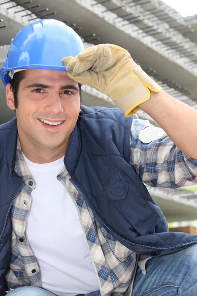 Gülen inşaat işçisi bir kask giyiyor — Stok fotoğraf