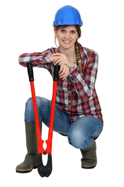Woman kneeling by bolt cutters — Stock Photo, Image