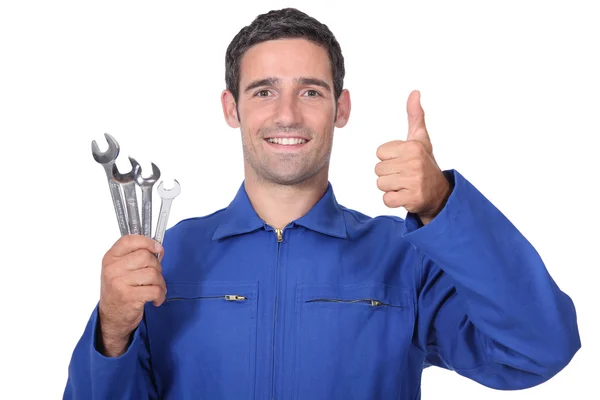 Head and shoulders portrait of plumber holding wrenches all smiles — Stock Photo, Image
