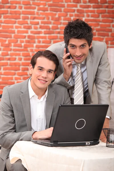 Young men using a laptop in a restaurant — Stock Photo, Image