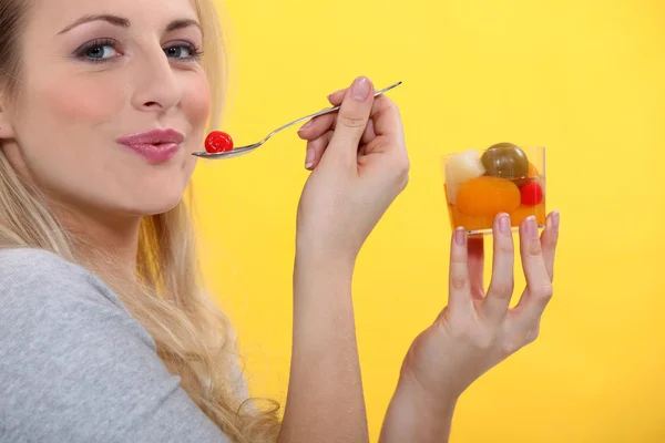 Mulher loira comendo coquetel de frutas — Fotografia de Stock