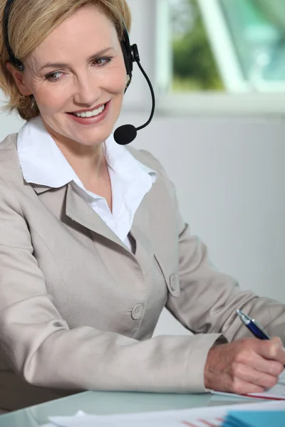 Frau lächelt mit Headset. — Stockfoto