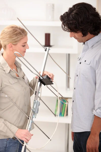 Man showing a woman how to set up an antenna — Stock Photo, Image