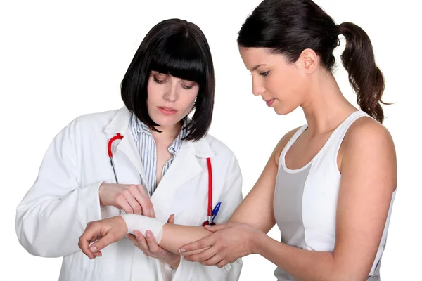 Arzt bandagiert das Handgelenk des Patienten — Stockfoto