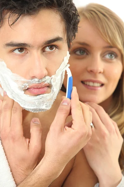 Young woman embracing her boyfriend while shaving — Stock Photo, Image