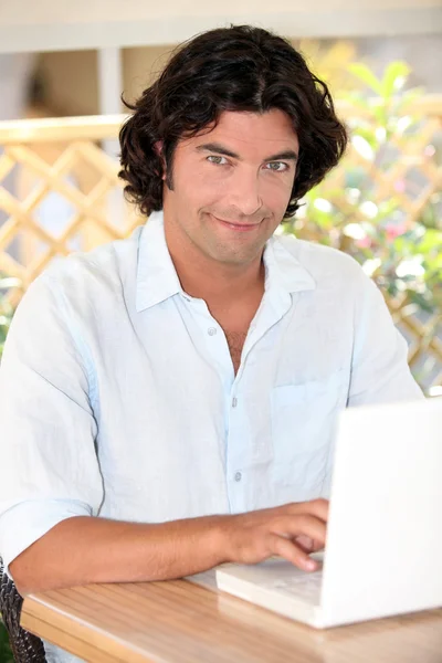 Retrato del hombre guapo de pelo oscuro que trabaja en el ordenador portátil —  Fotos de Stock
