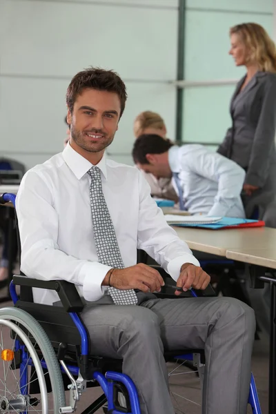 Homme travaillant dans un fauteuil roulant — Photo