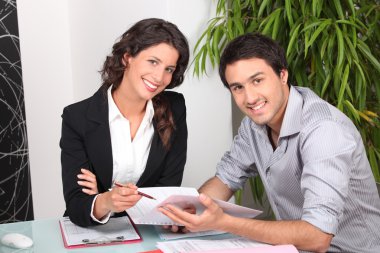 Businesswoman discussing a contract with her client clipart
