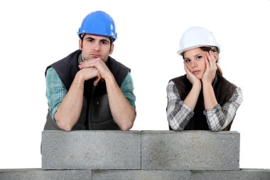 Unhappy team of bricklayers clipart