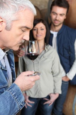 Man tasting wine in cellar clipart