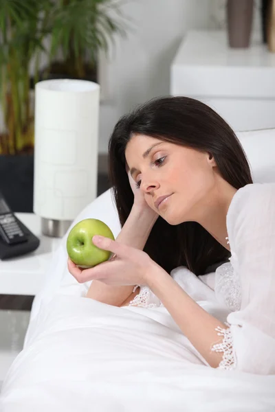 Elegante morena contemplando manzana verde — Foto de Stock