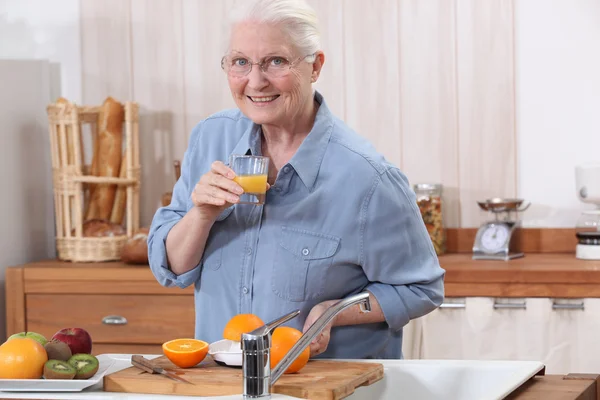 Een oude dame maken jus d'orange. — Stockfoto