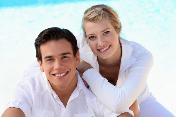 Paar zat bij het zwembad — Stockfoto