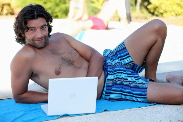 Man op laptop op strand — Stockfoto